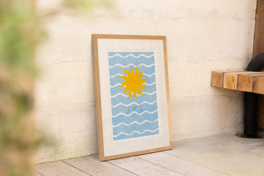 A picture of the sun and the ocean propped up against a wall