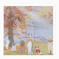 Autumn Dogs art card featuring six dogs in a park with orange autumn leaves, trees, and a white envelope.