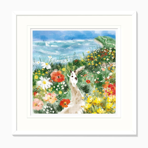 Patch Among the Wildflowers framed print featuring a spotted dog walking along a coastal path through colourful flowers.