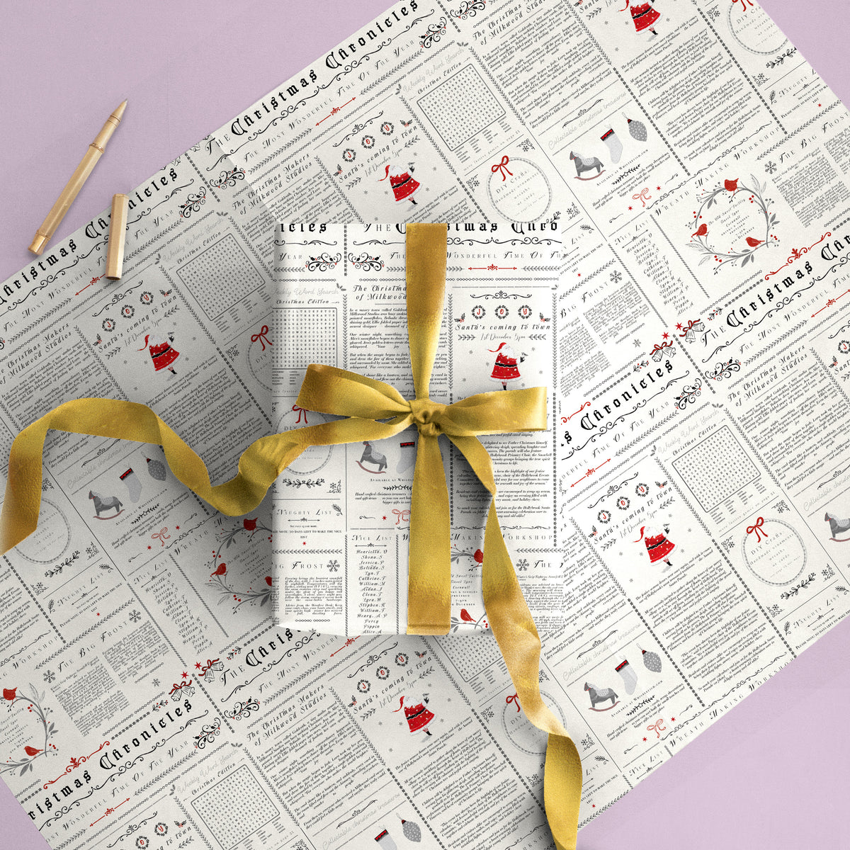 Chronicles Christmas wrapping paper featuring a newspaper-style print with red and black festive illustrations and a gold ribbon.