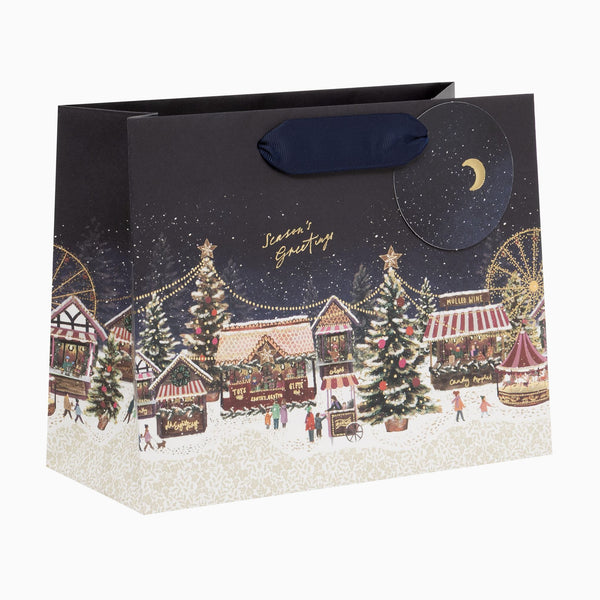 Christmas Market medium gift bag in navy blue with a festive scene of stalls, Christmas trees, and a crescent moon.