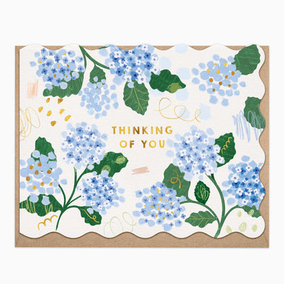 Hydrangeas Thinking Of You card with blue floral illustrations, scalloped edges, and a brown envelope.
