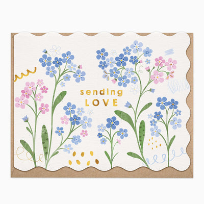 Forget Me Nots Sending Love greeting card with blue and pink floral illustrations and a scalloped edge on a brown envelope.