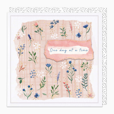 One Day At A Time greeting card with pink plaid background, delicate floral illustrations, and a spotted envelope.