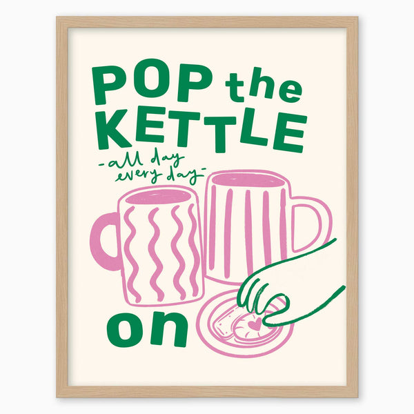 Pop the Kettle Pink framed print featuring green text, two pink mugs, and a biscuit on a light cream background.