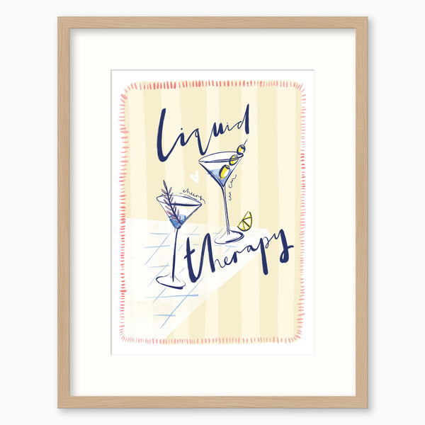 Liquid Therapy framed print featuring two martini glasses on a pale yellow striped background in a light wood frame.