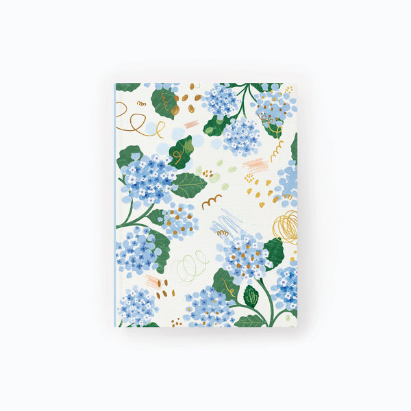 Hydrangea Notebook featuring a floral pattern of blue hydrangea flowers, green leaves, and gold abstract scribbles.