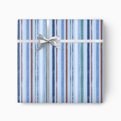Blue Stripes wrapping paper featuring vertical brushstroke lines in shades of blue, teal, and brown with a silver ribbon.
