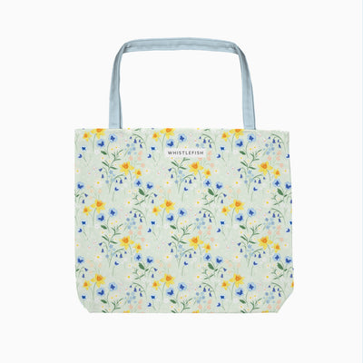 Cornish Bloom tote bag featuring a pale green floral pattern with yellow daffodils and blue flowers and pale blue handles.