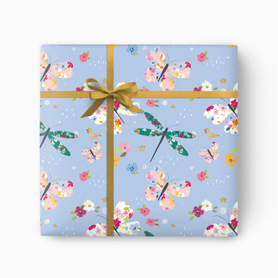 Ditsy Butterflies Blue wrapping paper featuring colourful floral butterflies and dragonflies tied with a gold ribbon.