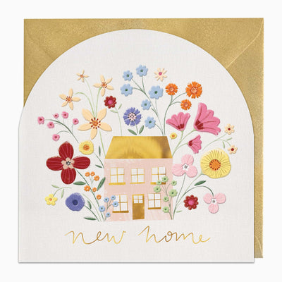 G435 - Floral Arch New Home card featuring a pink house surrounded by colourful flowers and gold lettering, with a gold envelope.