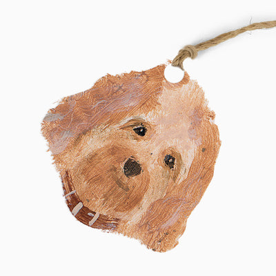 Hannah Cole dog gift tag featuring a brown, painted illustration of a dog's face with a jute string tie.