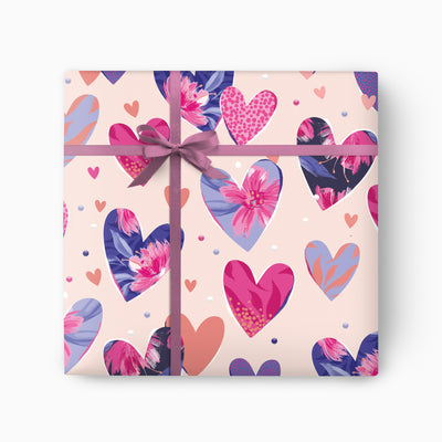 Hearts Wrapping Paper featuring a pattern of pink, blue and purple hearts with floral details, tied with a purple ribbon.