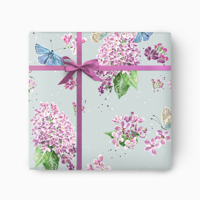 Lilac & Butterflies wrapping paper featuring purple floral clusters and blue butterflies on a pale green background with a bow.