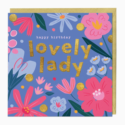 Lovely Lady birthday card with gold text on a blue background featuring pink and blue floral illustrations and gold dots.