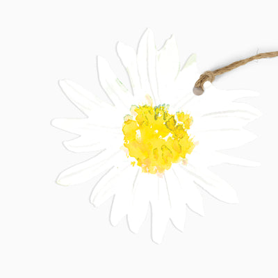 Meadow Morning gift tag shaped like a white daisy with a yellow centre, attached to a piece of natural jute twine.