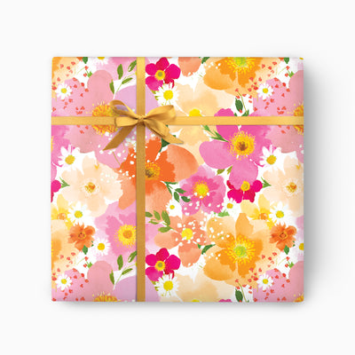 Petal Pop wrapping paper featuring a vibrant watercolour floral pattern in pink, orange, and yellow, tied with a gold ribbon.