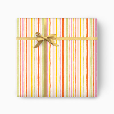 Pink Stripes wrapping paper featuring vertical lines in pink, orange, yellow and green, tied with a gold ribbon bow.