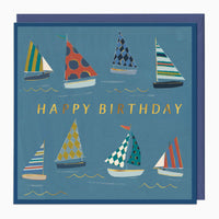 Sail Boats birthday card featuring colourful patterned sailboats on a blue background with gold Happy Birthday text.