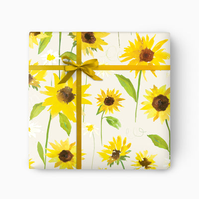 Sunflower Bloom wrapping paper featuring a watercolour pattern of yellow sunflowers and green leaves, tied with a gold ribbon.